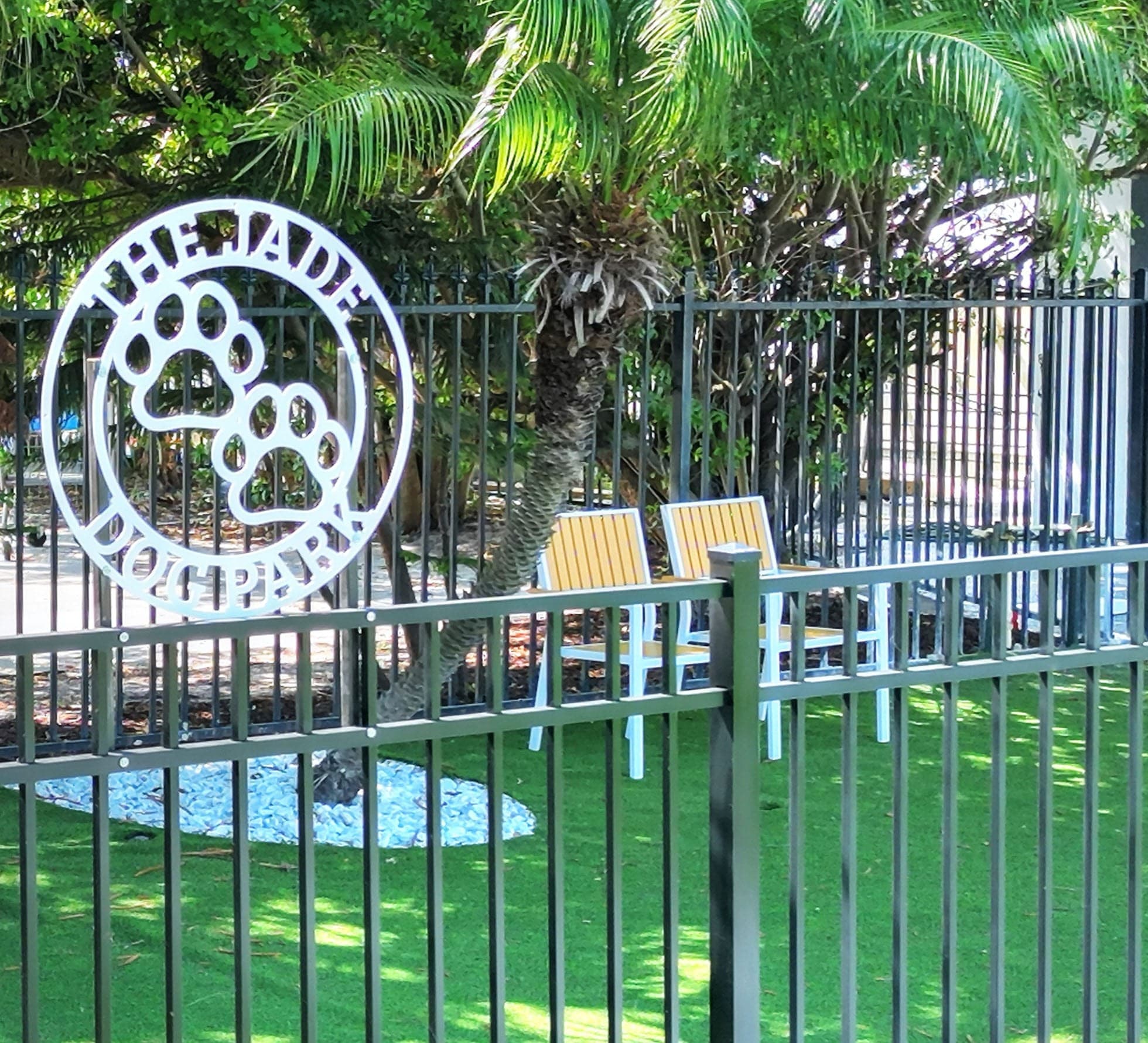 The fenced pet park with its paw-print gate sign