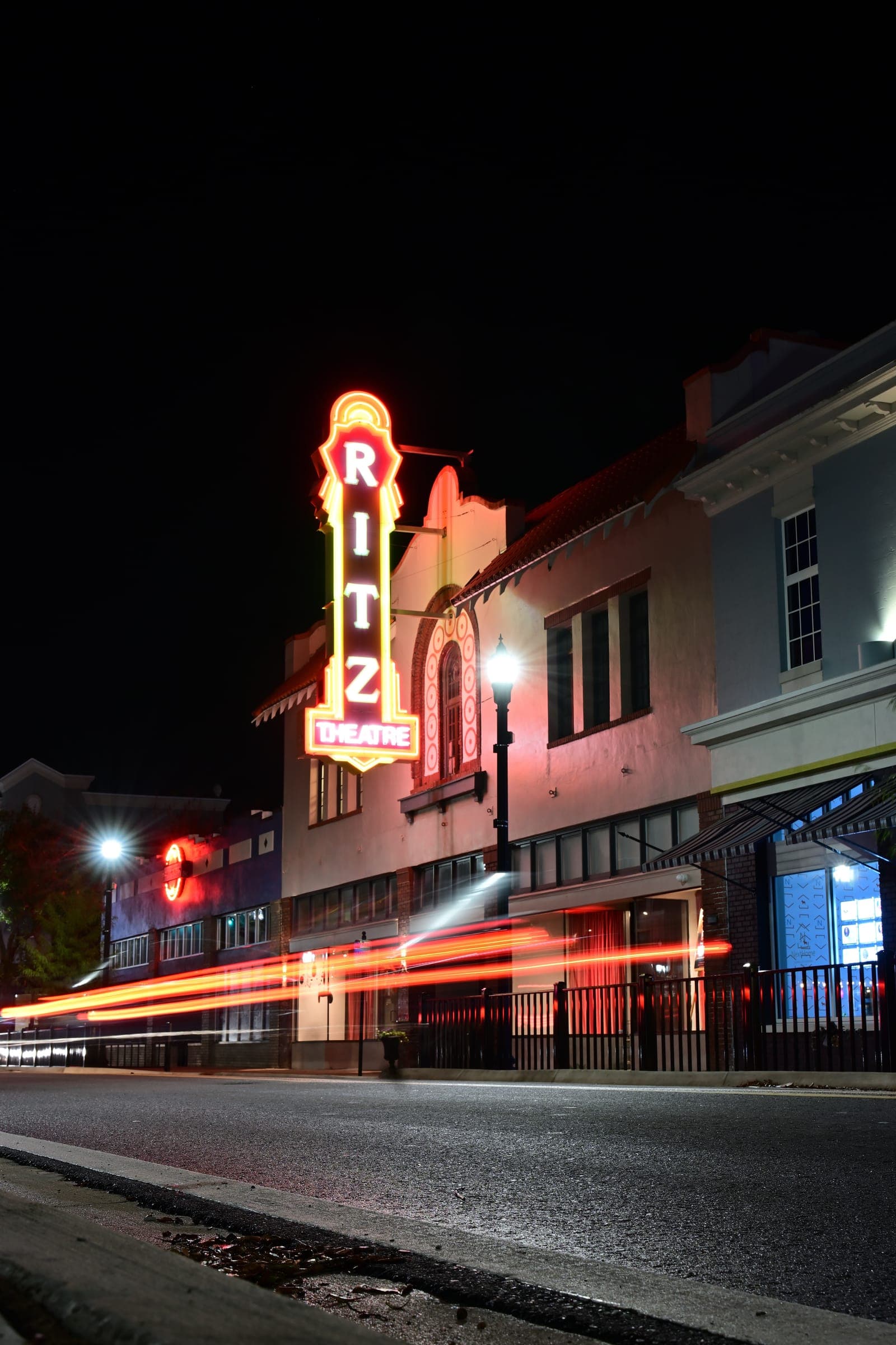 The Ritz Theatre marquee at night with car light trails along Central Avenue
