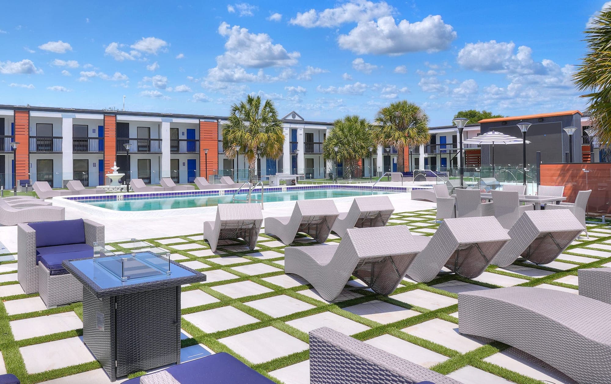Poolside loungers and fire tables on the paver lawn at The Jade